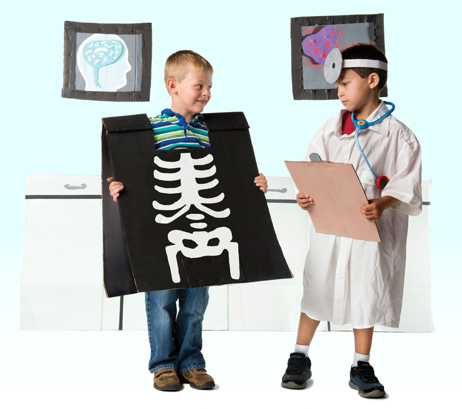 Photo of two children playing with cut-outs of x-rays and doctor's supplies in doctors office