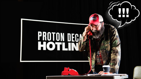 Proton decay hotline, man answering old red dial phone with "!!!"