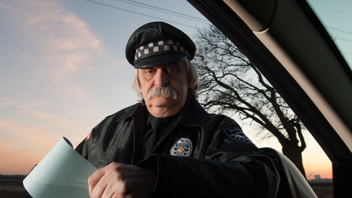 Photo of man that looks like Einstein dressed as cop pulling you over