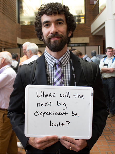 Photo of Jonathan Asaadi holding whiteboard that says "Where will the next big experiment be built?"