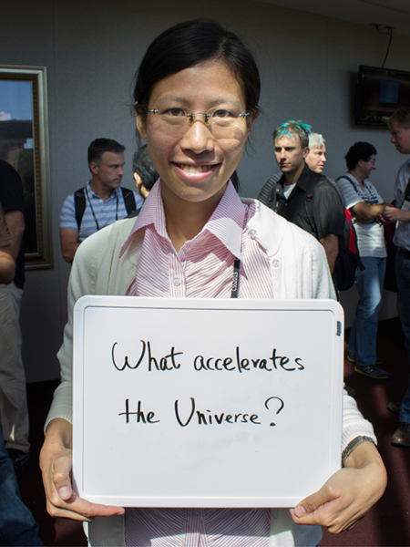 Photo of Hao-Yi Wu holding whiteboard that says "What accelerates the universe?"