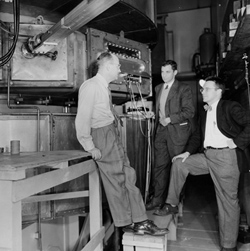 Enrico Fermi (left) chats with the designers of the cyclotron magnet, Herb Anderson and John Marshall. 