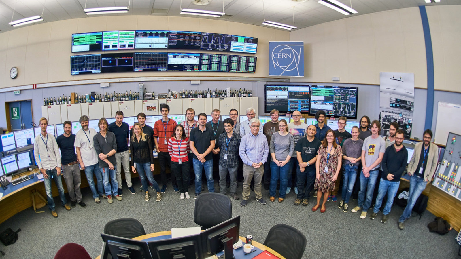 Group photo of about 30 people in the CERN Control Centre