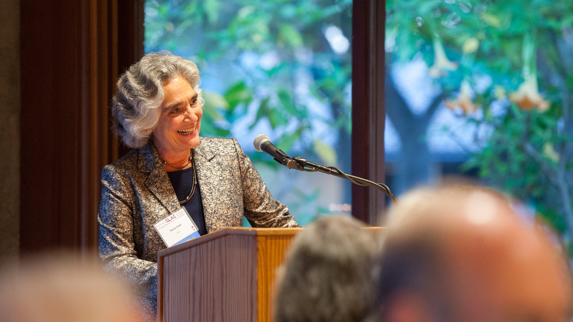 Photo of woman speaking at podium at SLAC Anniversary picnic