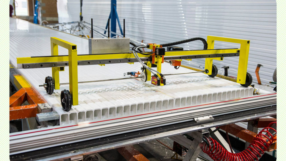 Photo of a machine rolls down an assembled PVC sheet, checking the alignment of the module cells