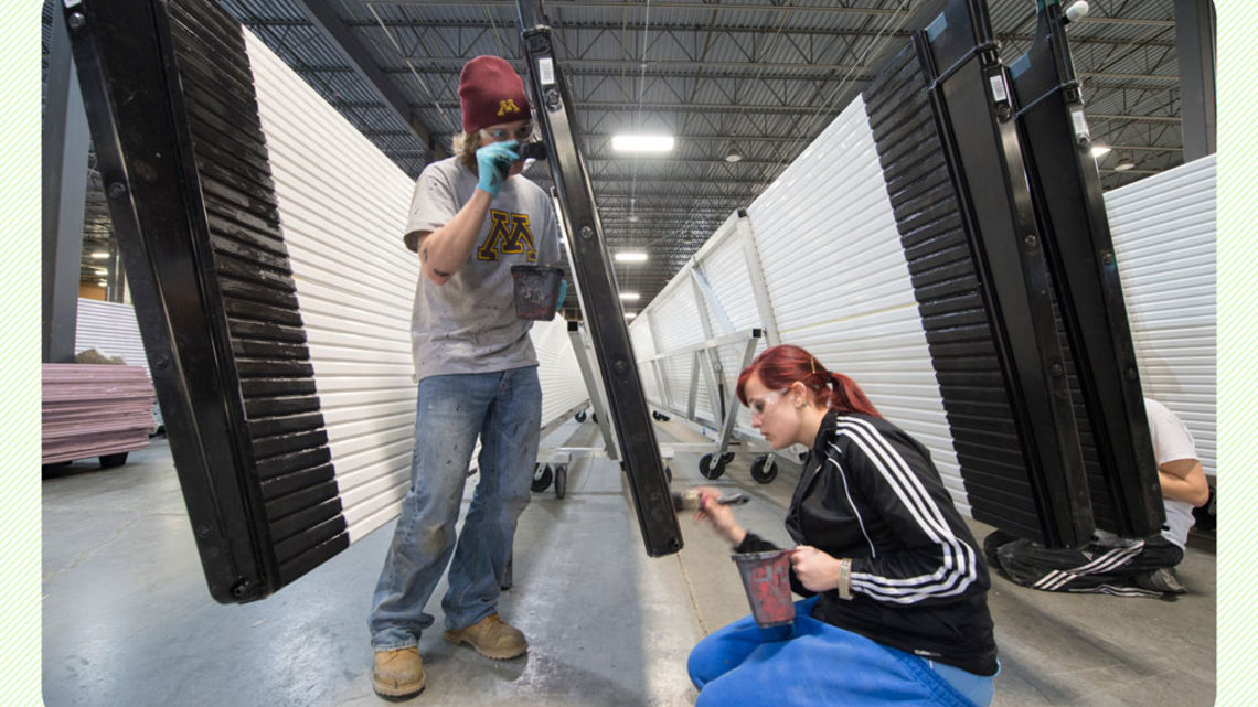 Photo of students apply light-blocking black paint to the edges of the PVC sheets