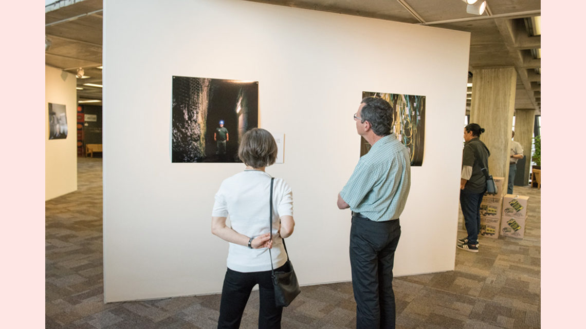 Photos in the exhibit are viewed by attendees