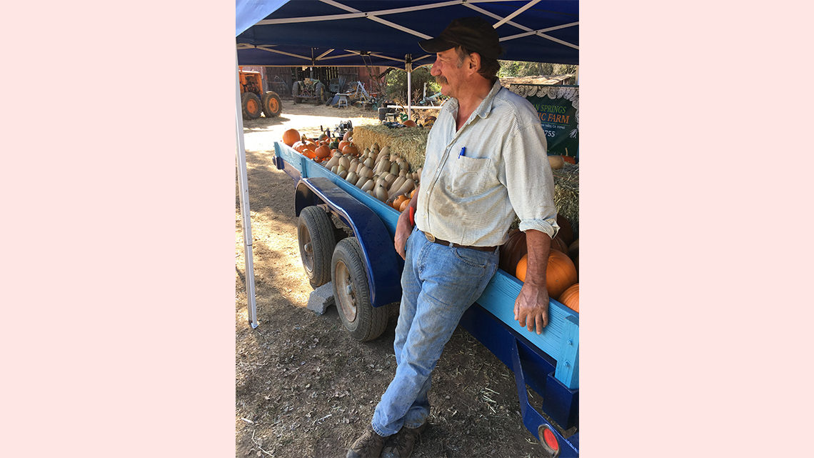 Pasner's dad rests next to a trailer full of produce