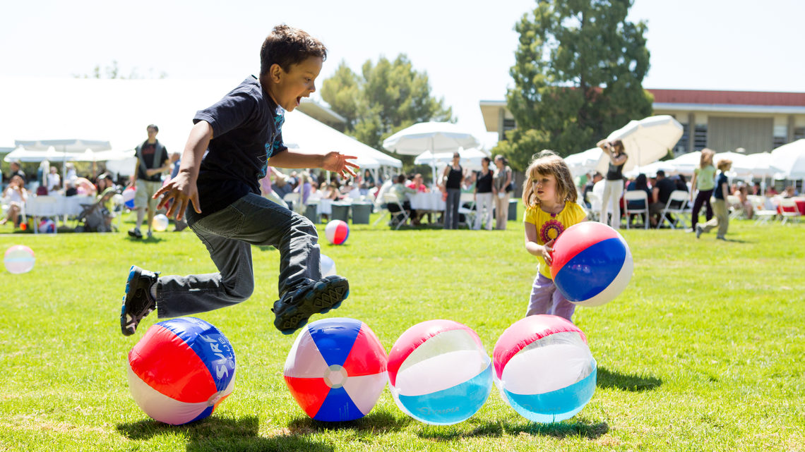 Photo of boy and girl playing with beach balls at SLAC Anniversary picnic