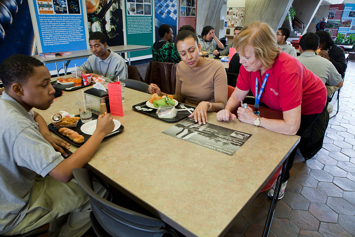 Photo of docent explaining information to people eating lunch