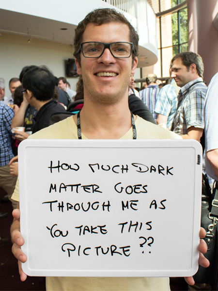Photo of Stefan Funk holding whiteboard that says "How much dark matter goes through me as you take this picture?"
