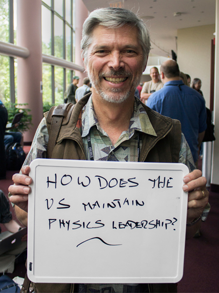 Photo of Kevin Lesko holding whiteboard that says "How does the US maintain physics leadership?"