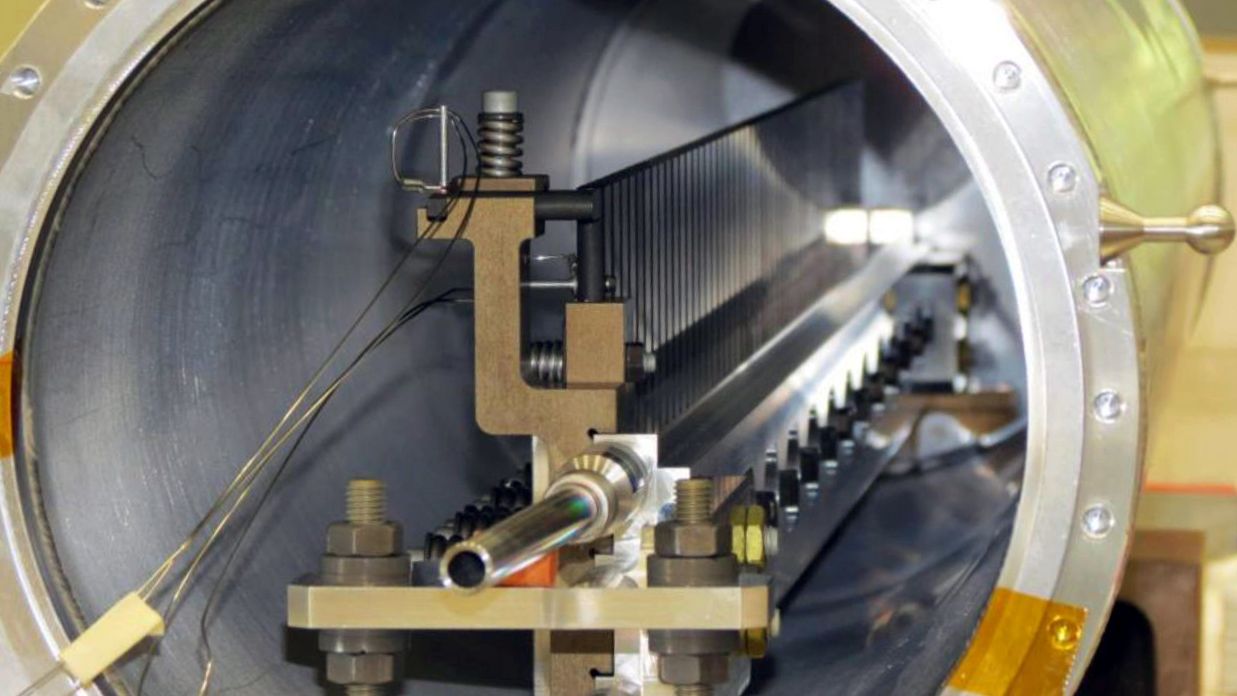 Photo of a row of slim silver objects sit in the center of a tube