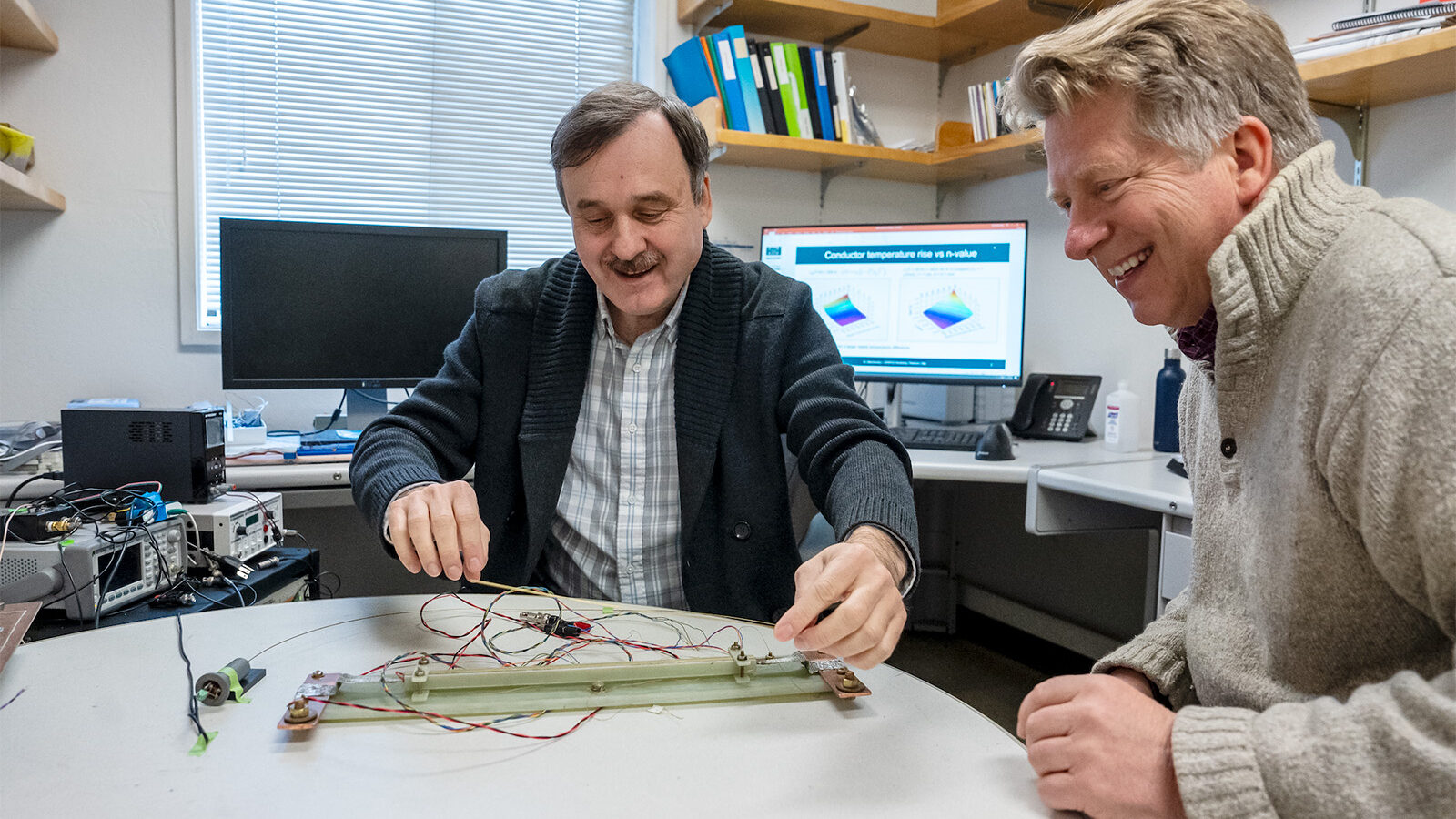 Maxim Marchevsky (left) and Soren Prestemon discussing an experimental setup to test the sensitivity of a temperature monitoring system for a high temperature superconducting magnet.