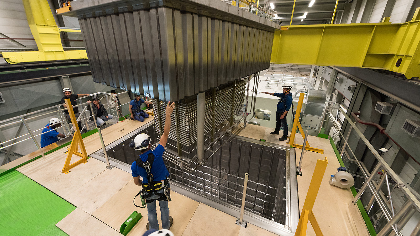 People in hard hats install the 311 detector