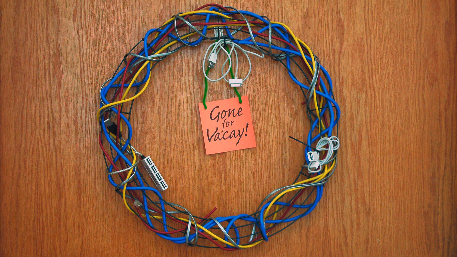 Wreath made of computer cables and post it note reading "Gone for Vacay"