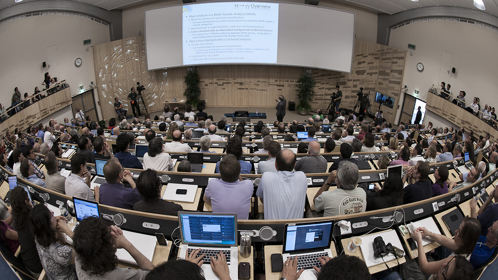 Photo from the back of a crowded conference room on the day of the Higgs announcement
