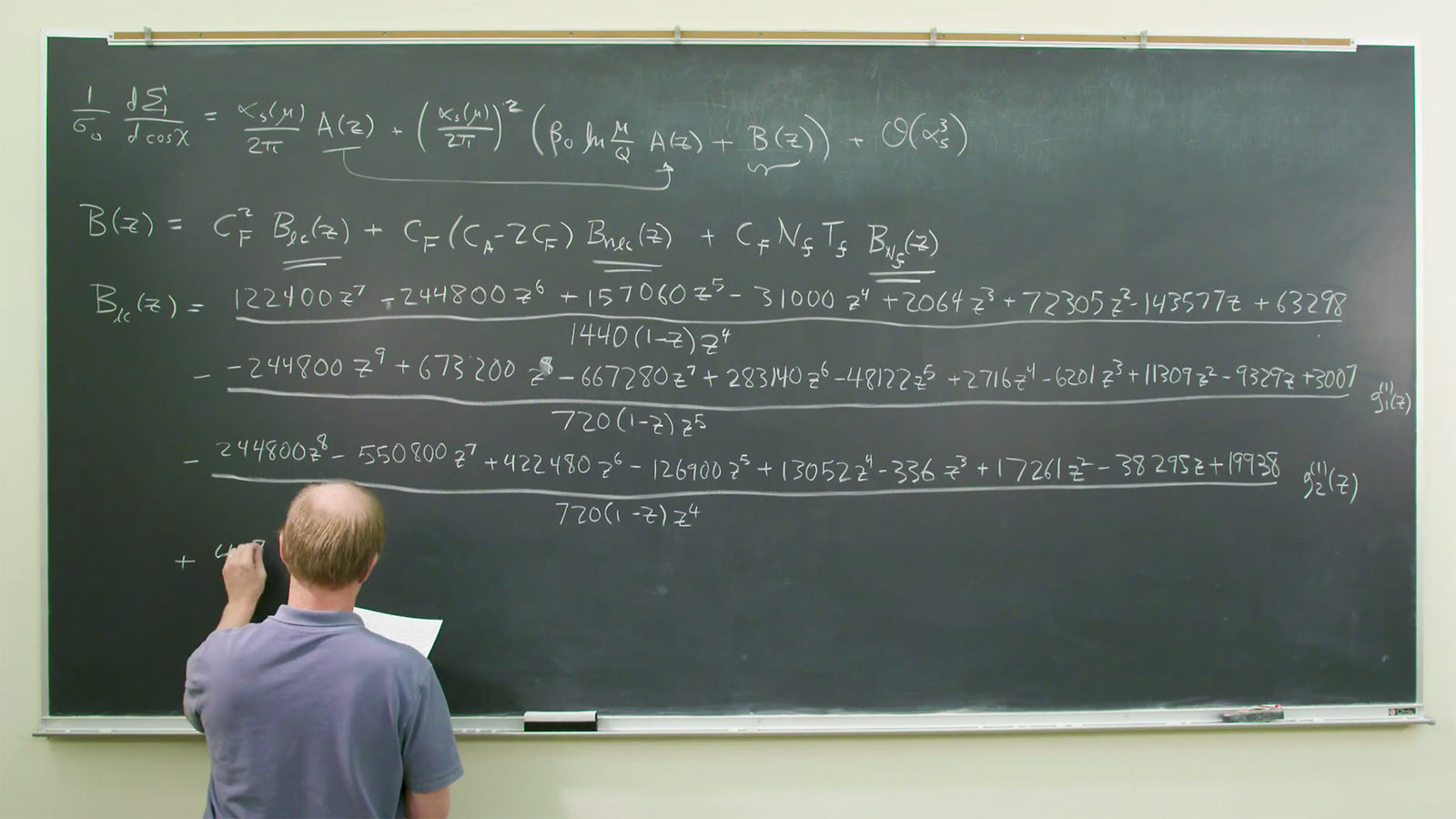 Video still showing theorist Lance Dixon writing on a large chalkboard