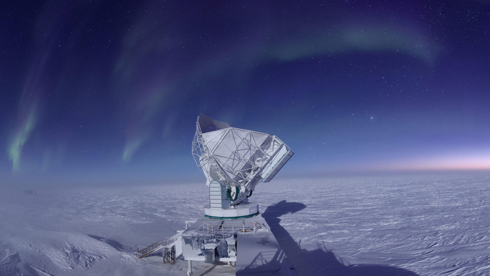 Photograph of a large telescope in the snow observing the night sky