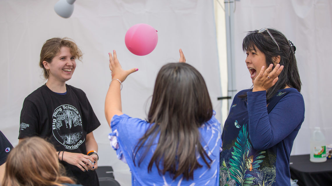 Attendees taking part in an experiment involving a balloon 