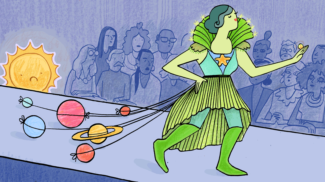 Woman in green dress walking down the runway with solar system train 