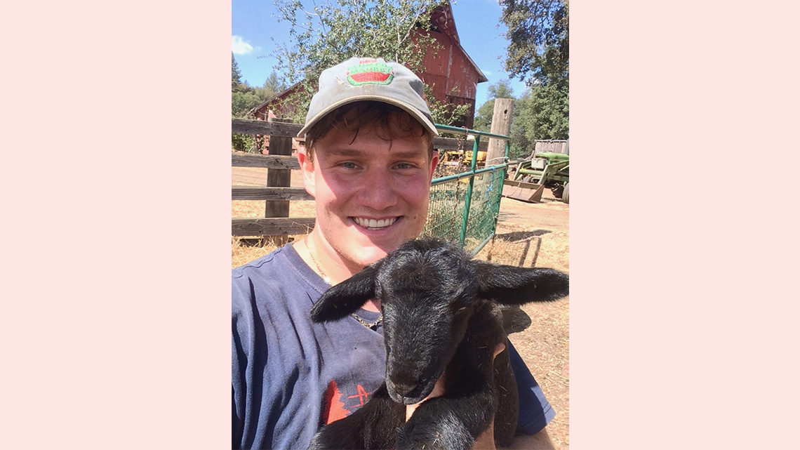 Pasner holds a goat on the farm