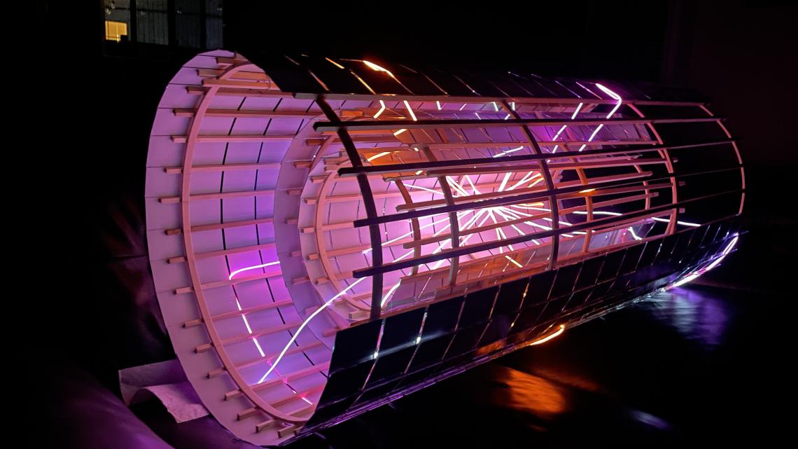Photograph of the Disco-tracker in the dark, with glowing wires representing particle tracks