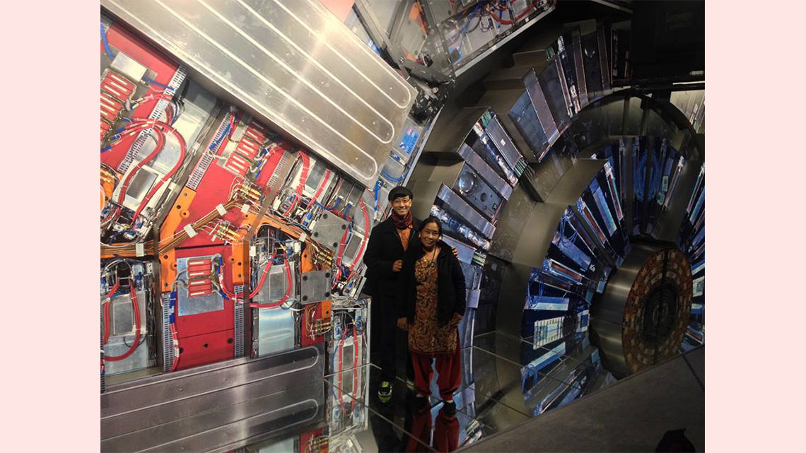Photo of two people posing in front of a display that resembles the CMS detector