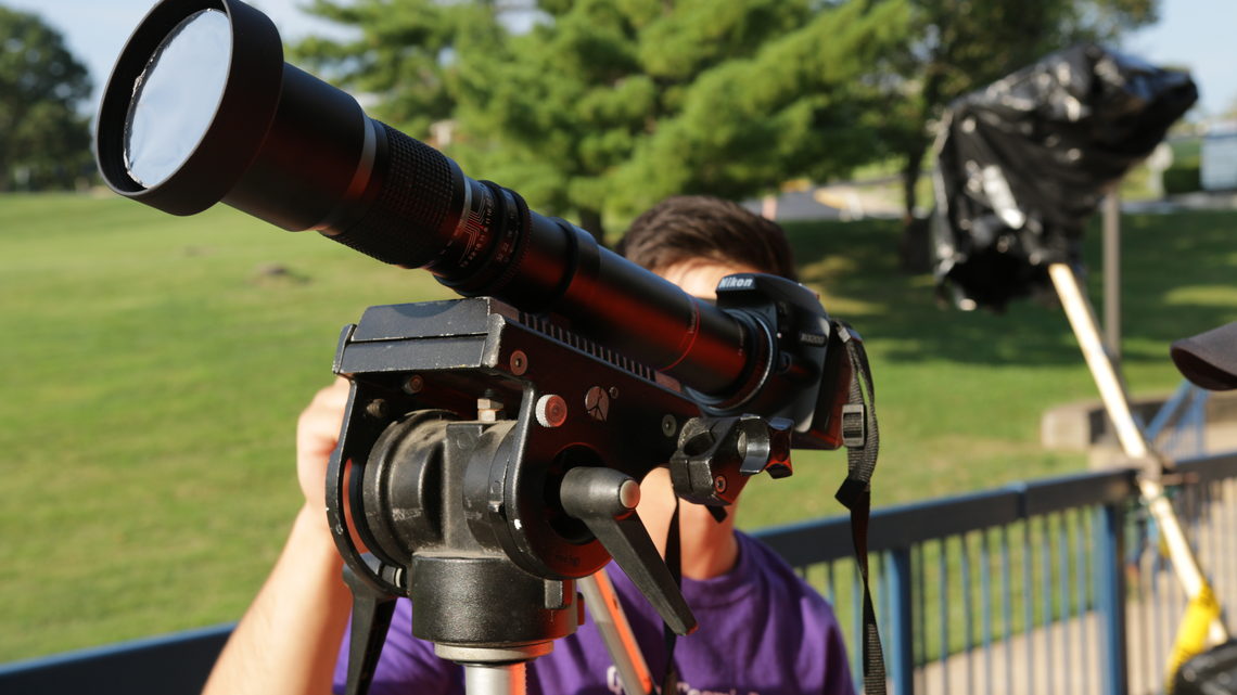 Photo of Glenbrook North High School student looking through telescope 