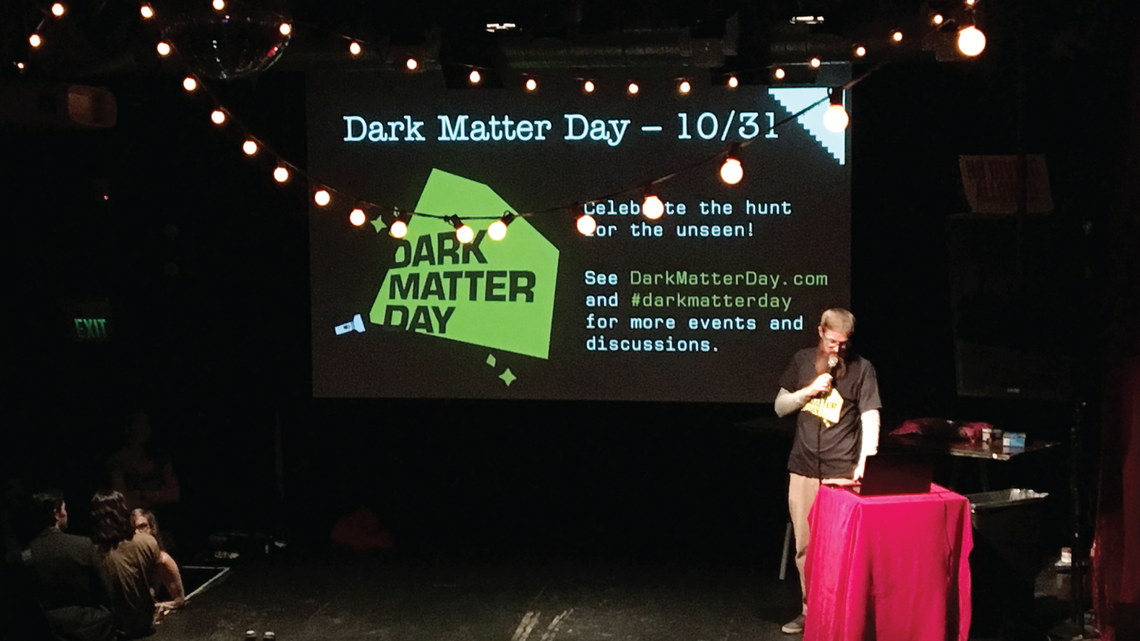 Bart Bernhardt, co-founder of Nerd Nite SF, donned a Dark Matter Day t-shirt during an October 18 event in San Francisco.