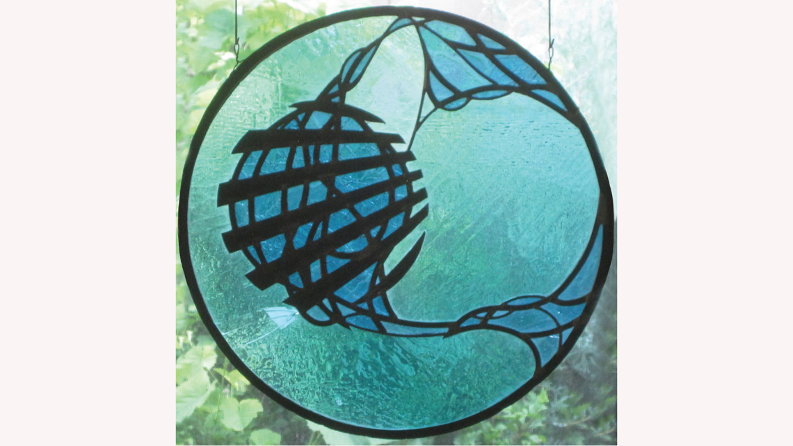 Circular stained glass piece in light and dark blue