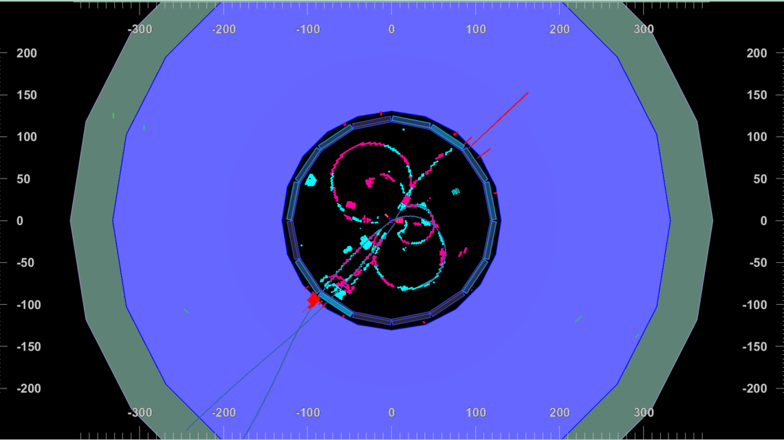 Image of pink and blue swirls radiate out from a black center: the first particle collisions seen by the Belle II detector.