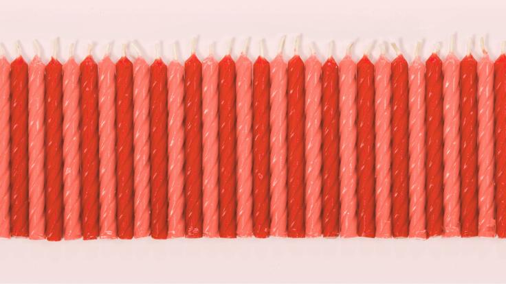 Row of red and pink candles with pink background 