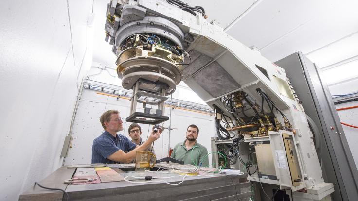 Tom Kroc, Matteo Quagliotto and Mike Geelhoed set up a sample beneath the A2D2 accelerator to test the electron beam.