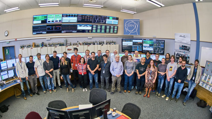 Group photo of about 30 people in the CERN Control Centre