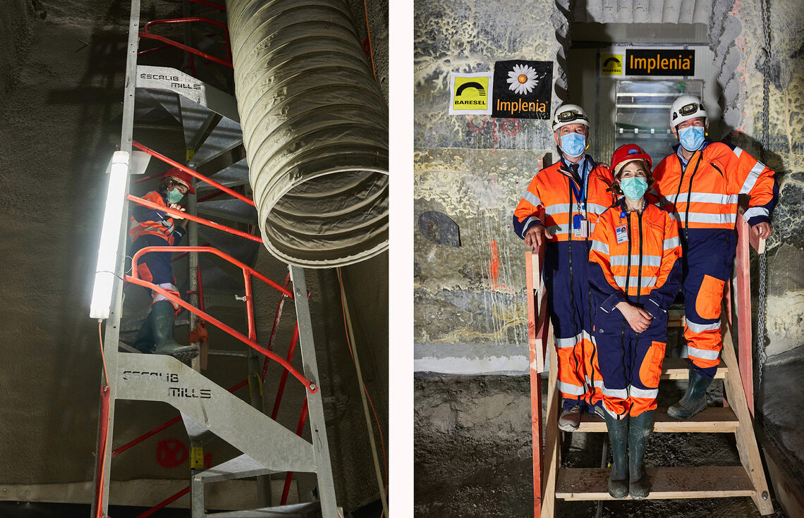 Leaders at CERN, dressed in orange work suits, descend the stairs and pose underground