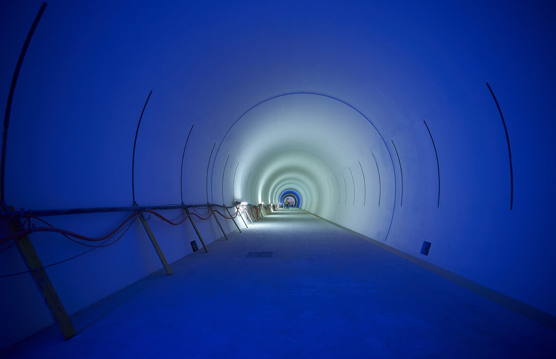 Clean, white tunnel illuminated by blue lights
